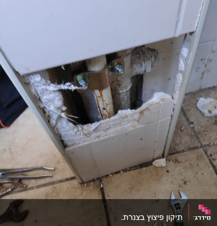 צינור חשוף עם מפתח ברגים על הרצפה